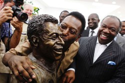 Pelé (left) plants a kiss on the bronze bust of himself